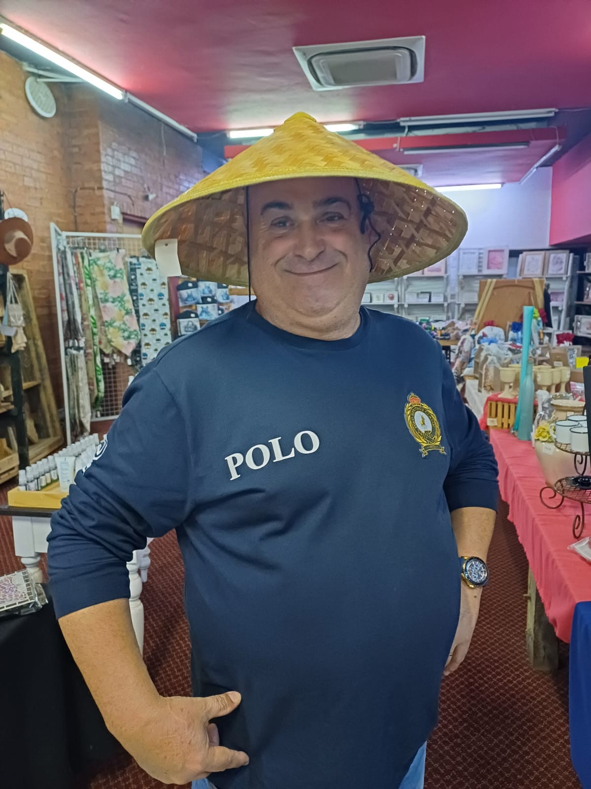 Dad grinning while trying on a wide yellow hat